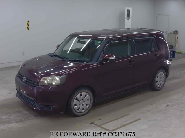 A grey sports car speeding down a highway at night.