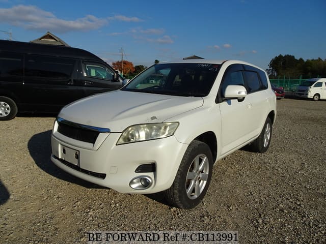 A grey JDM sports car speeding down a highway at night.