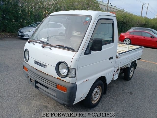 A grey sports car speeding down a highway at night.