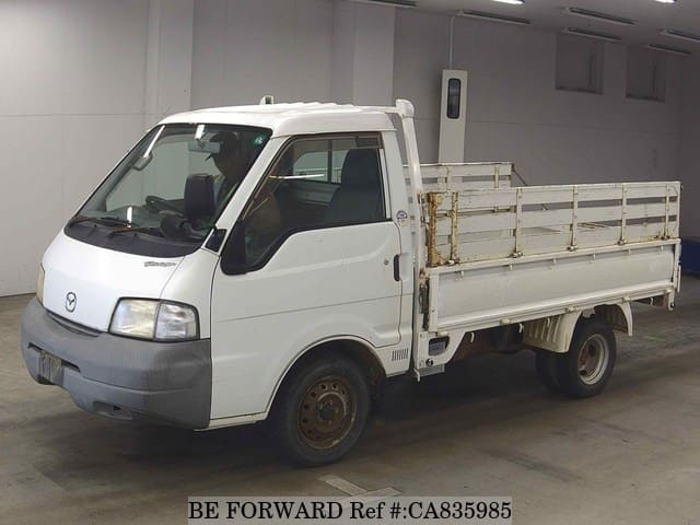 A grey JDM sports car speeding down a highway at night.