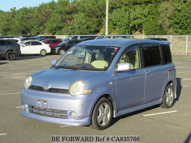 A grey JDM sports car speeding down a highway at night.