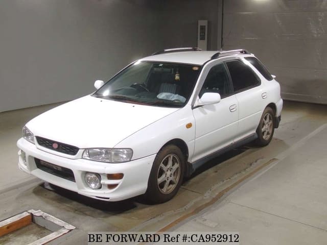 A grey JDM sports car speeding down a highway at night.