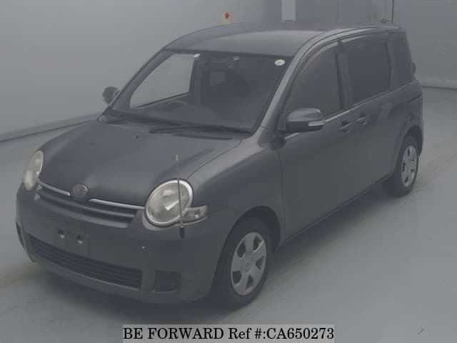 A grey JDM sports car speeding down a highway at night.