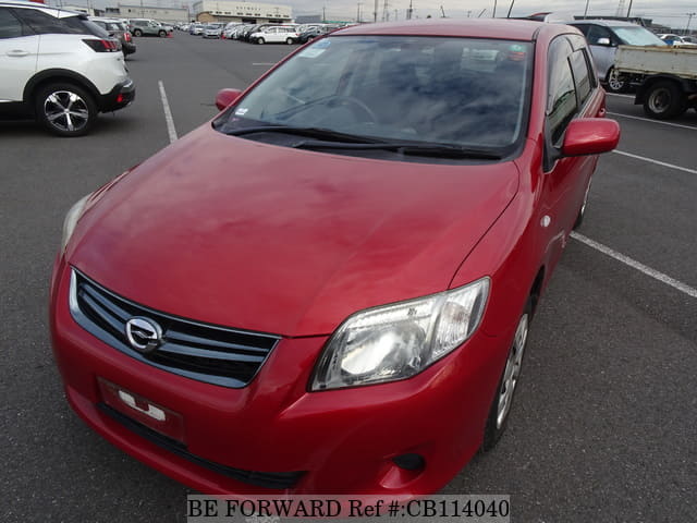 A grey sports car speeding down a highway at night.