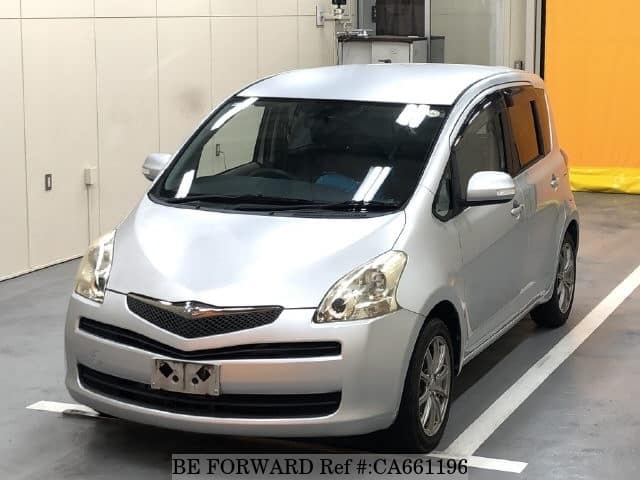 A grey JDM sports car speeding down a highway at night.