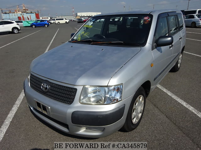 A grey JDM sports car speeding down a highway at night.