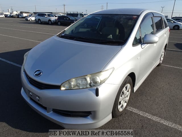 A grey sports car speeding down a highway at night.