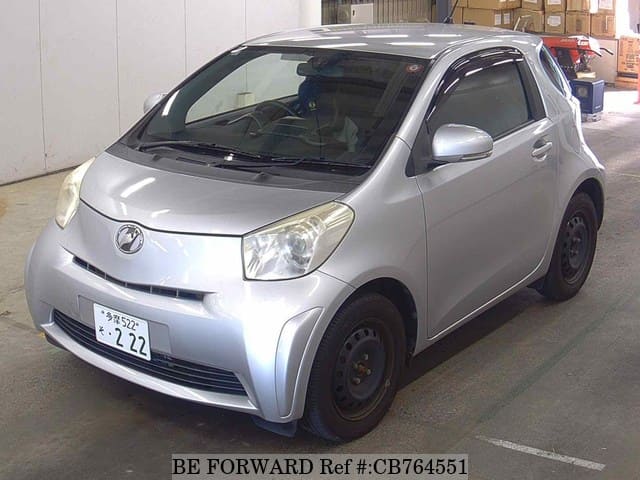 A grey JDM sports car speeding down a highway at night.