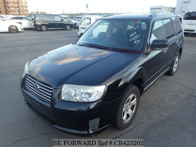 A grey sports car speeding down a highway at night.