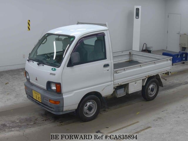 A grey JDM sports car speeding down a highway at night.