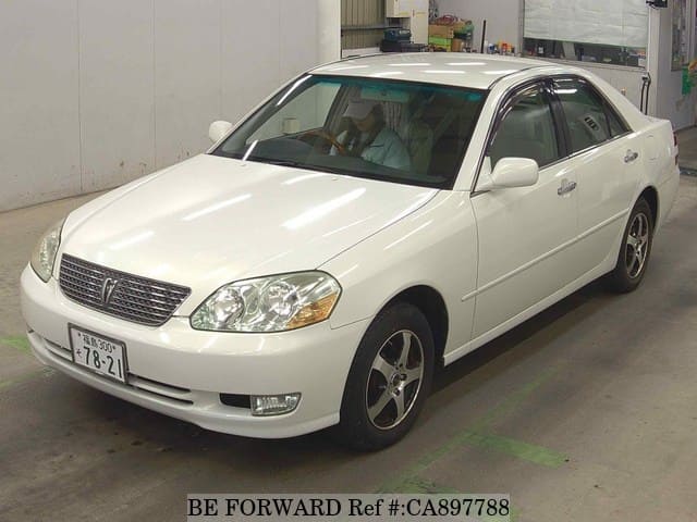 A grey JDM sports car speeding down a highway at night.
