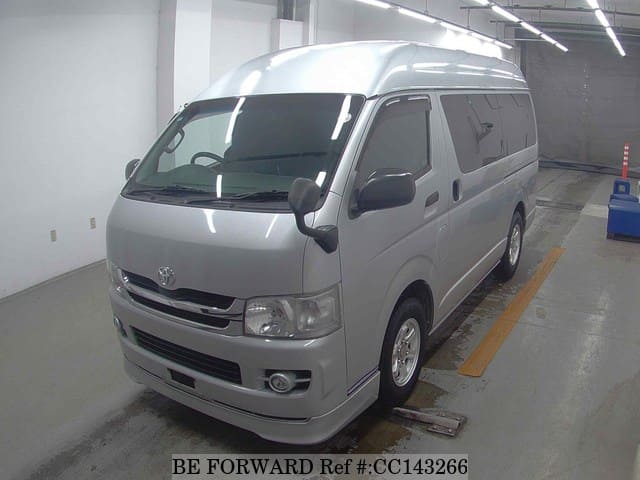 A grey sports car speeding down a highway at night.