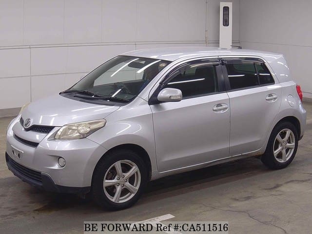 A grey JDM sports car speeding down a highway at night.
