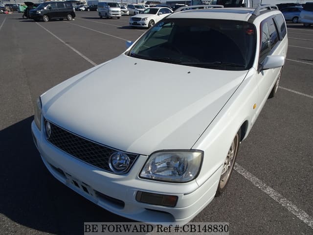 A grey JDM sports car speeding down a highway at night.
