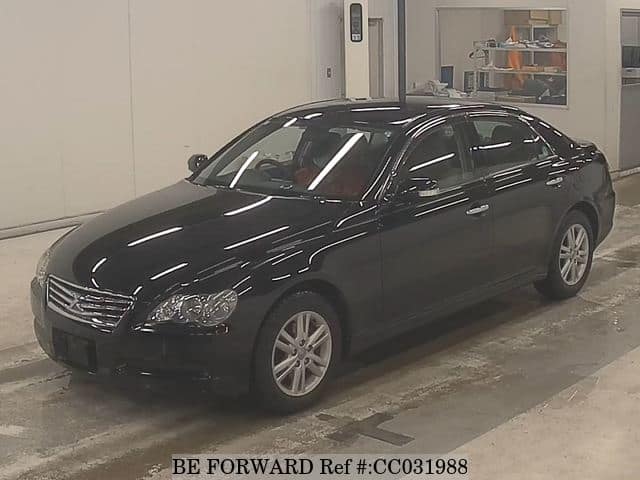 A grey sports car speeding down a highway at night.