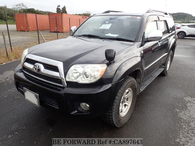 A grey sports car speeding down a highway at night.