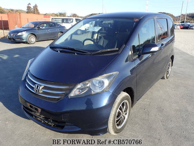 A grey JDM sports car speeding down a highway at night.