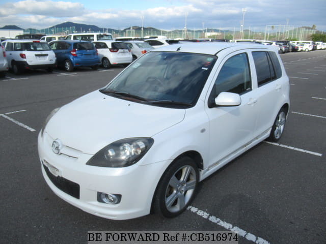 A grey JDM sports car speeding down a highway at night.