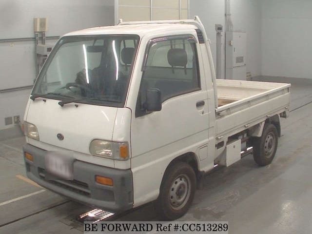 A grey sports car speeding down a highway at night.