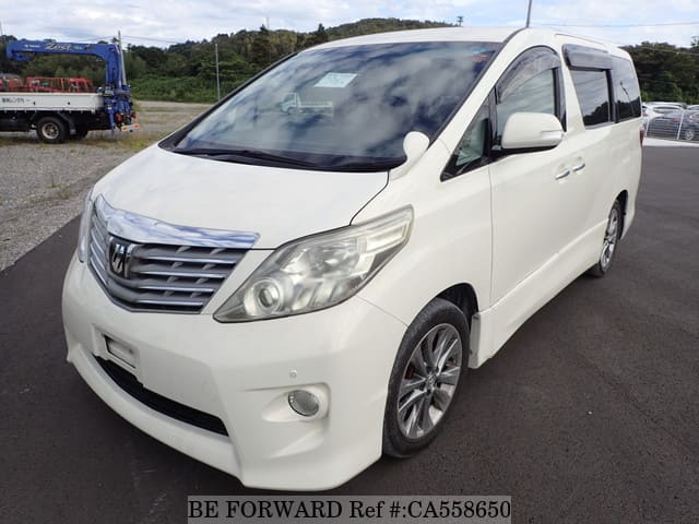 A grey JDM sports car speeding down a highway at night.