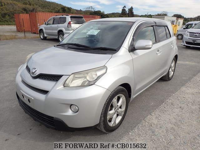 A grey JDM sports car speeding down a highway at night.