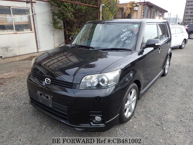 A grey JDM sports car speeding down a highway at night.