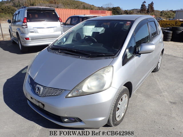 A grey JDM sports car speeding down a highway at night.