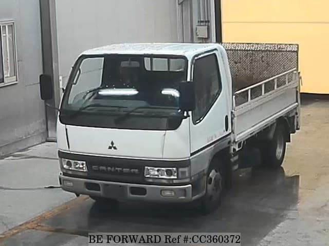 A grey sports car speeding down a highway at night.