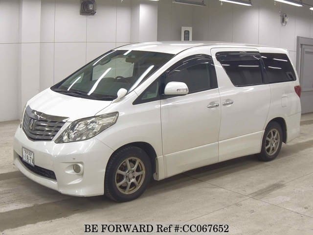 A grey sports car speeding down a highway at night.