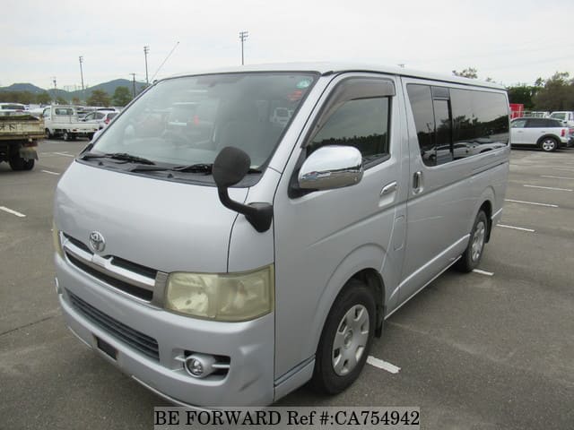 A grey JDM sports car speeding down a highway at night.
