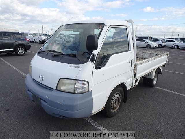 A grey JDM sports car speeding down a highway at night.