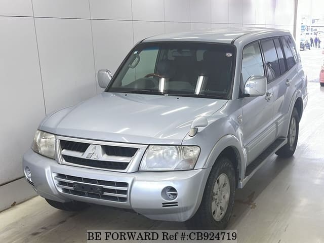 A grey sports car speeding down a highway at night.