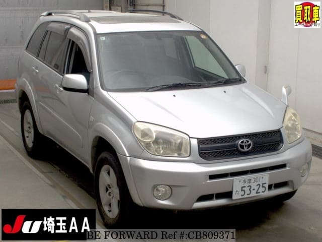 A grey JDM sports car speeding down a highway at night.