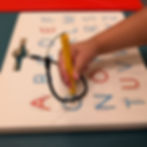 autistic kid using writing tool for writing letters