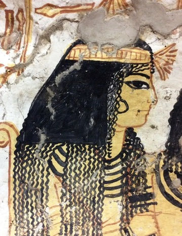Ancient Egyptian wall painting of a woman with long, elaborately braided and wavy black hair in traditional profile style.