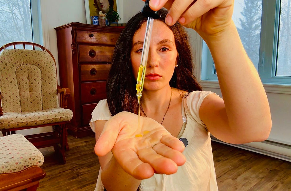 "Woman with floor-length dark hair applying nourishing herbal oil from dropper to palm for scalp and hair treatment, modern Edwardian-inspired hair oiling routine to supplement natural sebum, boost shine, and support length retention following Aline Vallandri's 1912 brillantine advice