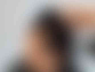 Close-up profile view of a woman with dark curly hair showing significant thinning and visible scalp at the crown. A hand parts the hair to reveal the extent of hair loss and shedding.