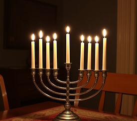 A menorah with candles lit on a kitchen table. The background is dark..jpg
