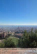Cityscape view of Barcelona from a hilltop, with iconic skyline features and a clear blue sky above, evoking a serene mood.