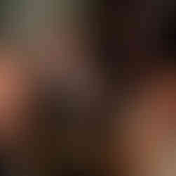 Two men and a woman sat down in a bar putting their fingers to their lips