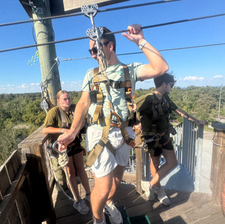 Man in mint T-shirt and white shorts holds onto zip line before commencing