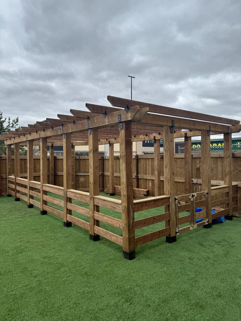Completed custom treated pine pergola with railings and decorative beams in Edmonton outdoor play area