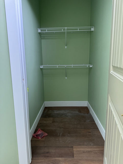 Finished white baseboards installed inside a walk-in closet in Boyle, Alberta
