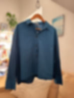 Blaues Hemd auf Kleiderbügel, vor weißer Wand. Upcycling Hemd Gap - Surferin