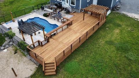 pressure treated wood deck overlooking in ground pool with slated wood pergola