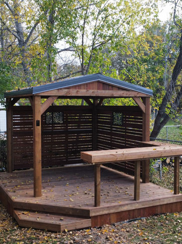 gazebo with metal roof and privacy screen surrounding ontop of wooden deck