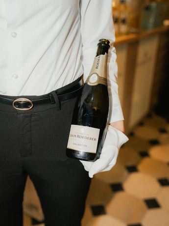 Nahaufnahme einer Hand, die ein Glas Champagner hält, aufgenommen in Baden-Baden.
