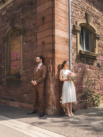 Brautpaar lehnt entspannt an einer Sandsteinwand, romantisches Hochzeitsshooting. Hochzeitsfotograf Karlsruhe für stilvolle Aufnahmen.