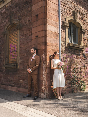 Brautpaar lehnt entspannt an einer Sandsteinwand, romantisches Hochzeitsshooting. Hochzeitsfotograf Karlsruhe für stilvolle Aufnahmen.
