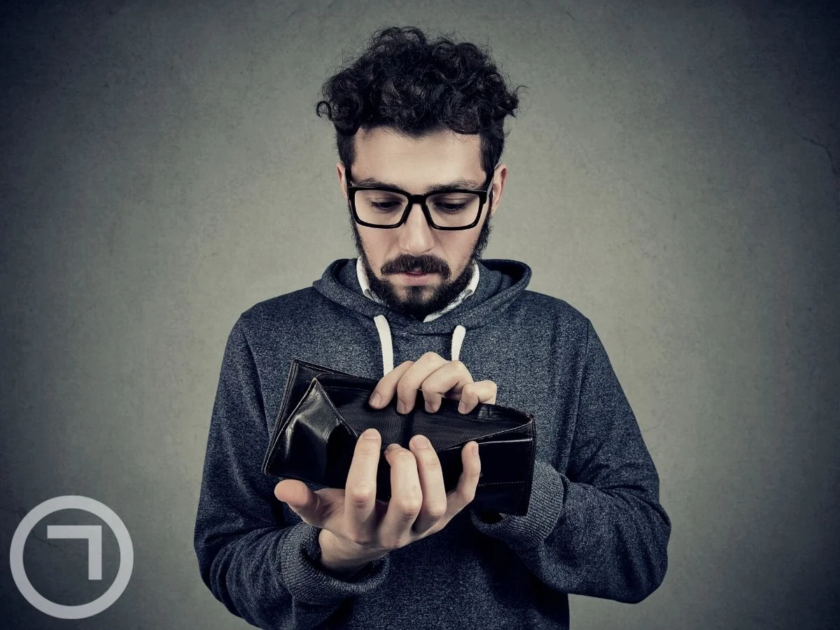 A man looking into his empty wallet